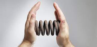 An image of two hands holding a coiled spring